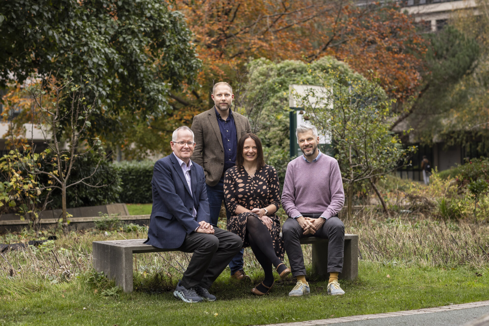A photograph of the HASP senior leadership team, taken outside on a bench in front of greenery.