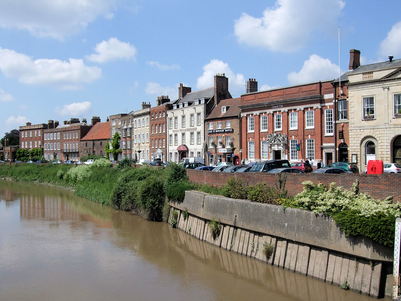 Row of houses by a river - to represent Zoopla property listings for research.